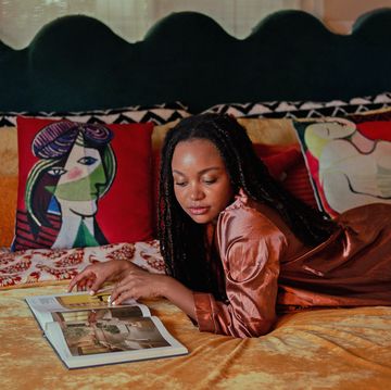 girl laying on bed reading a book